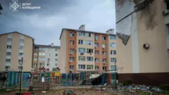 Многоэтажный дом и детская площадка перед ним, попавшие под удар.