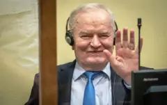 Ratko Mladic saluda sonriente en el juicio que le condenó.