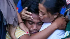 Korban selamat tenggelamnya KMP Tunu Pratama Jaya dipeluk keluarganya usai diserahkan oleh Tim SAR gabungan di Pelabuhan Ketapang, Banyuwangi, Jawa Timur, Kamis (03/07).