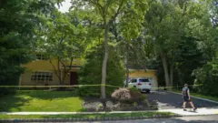 Vista da residência amarela da juíza distrital americana Esther Salas, cercada com fita da polícia no lado de fora