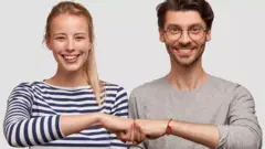 Хлопець і дівчина торкаються кулаками