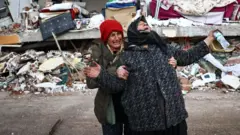 Women react at the site of a collapsed building in the aftermath of a major earthquake in the Elbistan district of Kahramanmaras in Turkey
