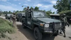 Abasirikare bo mu mutwe w'ingabo z'akarere k'Afurika y'uburasirazuba (EACRF) ubwo bari baherekeje abanyamakuru babajyanye kubereka mu duce tugenzurwa n'inyeshyamba za M23 i Bunagana mu burasirazuba bwa DR Congo, ku itariki ya 19 Mata (4) mu 2023. 