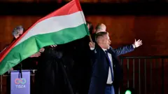 Peter Magyar, lider opozycyjnej partii Tisza, trzyma flagę po ogłoszeniu częściowych wyników wyborów parlamentarnych w Budapeszcie na Węgrzech
