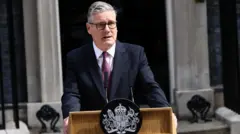 ダークスーツ姿のスターマー氏が首相官邸前で演台の後ろで演説している