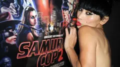 A atriz Bai Ling beija um pôster de Samurai Cop 2 na estreia do filme em 2015