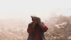deprem yıkıntıları arasında bir Afgan 