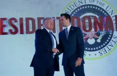 Donald Trump dándole la mano a Charlie Kirk.