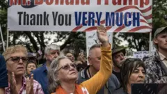 Manifestantes brancos agradecem a Trump num comício em Pretória.