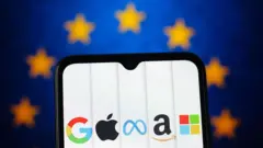 موبایل با علائم شرکت‌های عظیم آمریکایی در مقابل پرچم اتحادیه اروپا