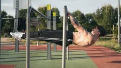 Homem fazendo exercício em academia ao ar livre