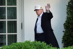 Donald Trump de boné acena se despedindo