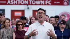 Burnham Ashton-in-Makerfield'deki Ashton Town FC'de konuşma yaparken. 19 Haziran 2026, Cuma