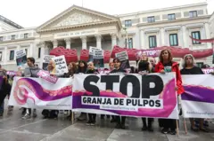 Um grupo de ativistas segura uma faixa e cartazes durante uma manifestação em frente ao Congresso dos Deputados, em Madri, para exigir que o governo impeça a empresa pesqueira Nueva Pescanova de construir uma fazenda de polvos em Las Palmas