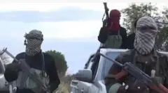 Awon agbebọn to gbe ibọn dani, bo oju wọn duro siwaju ọkọ ninu igbo, ẹnikan wa ninu ọkọ naa ninu wọn