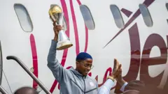 Rasheedat Ajibade hoists di Wafcon trophy as di Super Falcons arrive Abuja on July 28, 2025