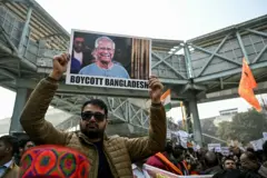 মুহাম্মদ ইউনূসের ছবির নিচে 'বয়কট বাংলাদেশ' লেখা নিয়ে বিক্ষোভ করেন একজন 