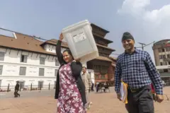 काठमाण्डूको वसन्तपुर दरबारक्षेत्रमा मतदानसम्बन्धी सामग्री बोकेर हिँडिरहेका निर्वाचन कर्मचारी