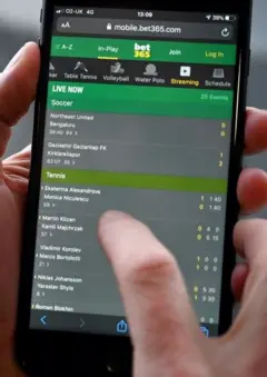 Uma mão mexendo em um site de bets no celular