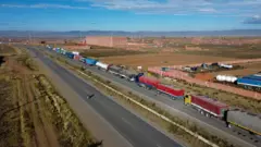 Uma imagem aérea mostra caminhões enfileirados após ficarem parados por dias, enquanto manifestantes bloqueavam uma rodovia principal exigindo a renúncia do presidente Rodrigo Paz em meio a uma crise econômica e de combustíveis, em Apacheta, Bolívia, em 13 de maio de 2026.