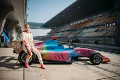 Rachel Robertson, sentada sobre um carro da F1 Academy em uma pista de corrida