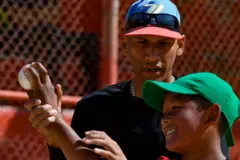 Um treinador ensina uma criança a arremessar a bola