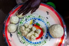 Ori to wa ninu abọ fifẹ, ti ọwọ obinrin kan n pin si kekeeke