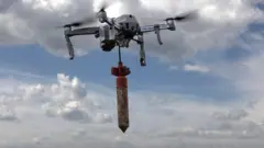 Um drone ucraniano com uma bomba pendurada nele.
