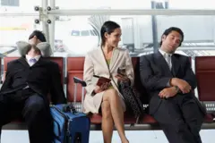 Üç yolu havalimanında oturuyor. İki erkek yolcu jet lag olduğu için uyuyor, ortadaki kadın yolcu ise elinde telefonu ve belgeleriyle gülümsüyor.