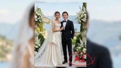 AI‑generowane zdjęcie przedstawiające parę ubraną w stroje ślubne, stojącą razem na tarasie z widokiem na jezioro i otoczoną dekoracjami z białych kwiatów. Obraz ma symulować scenę ślubu Zendayi i Toma Hollanda.