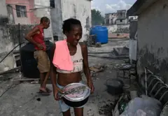 Una mujer carga una olla durante un apagón en La Habana