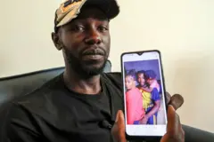 Mbengue Nyimbilo Crepin, également connu sous le nom de Pato, tient une photo de sa femme et de sa fille.