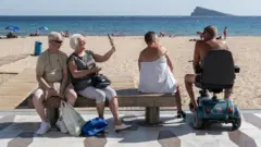 Brytyjscy turyści na plaży w Benidormie.