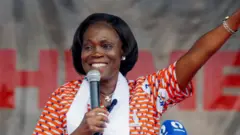 Simone Gbagbo se tient derrière un pupitre et parle dans un micro.