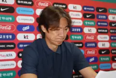 한국 축구 국가대표팀 홍명보 감독이 푸른 셔츠를 입고 굳은 표정을 한 채 기자회견을 하고 있다.