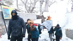 मुस्ताङ जिल्लाको मुक्तिनाथमा हिउँ परेका बेला एक दर्शनार्थीलाई डोलीमा बोकेर मन्दिरतिर लगिँदै