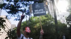 Manifestante segura um cartaz escrito "delata Vorcaro" em um protesto contra a corrupção.