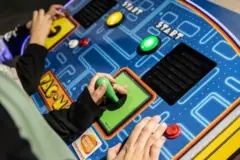 Mãos de crianças em um fliperama