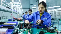Una mujer china trabajando en una fábrica de drones.