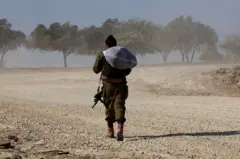 جندي إسرئيلي يمشي في منطقة غلاف غزة