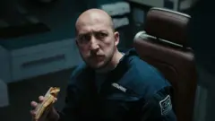 Чоловік їсть бутерброд