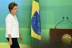 Dilma ao lado de uma bandeira do Brasil