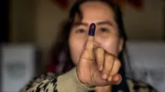 Seorang perempuan menunjukkan jari setelah menggunakan hak suaranya dalam pemilihan kepala daerah serentak di Jakarta pada 27 November 2024.