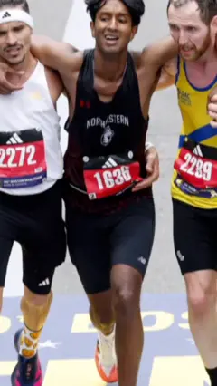 dva trkaca pomazu trecem i nose ga da zavrsi bostonski maraton