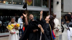 Pikin wey dey hold flowers while graduates celebrate