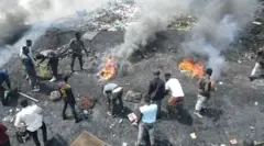 Men at the Agbobloshie dump burn cables and plastic.