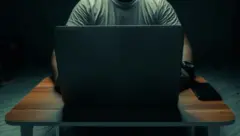 Um homem em frente a um computador