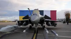 На цій фотографії зображено винищувач Rafale і ракету Storm Shadow (Scalp) на тлі національних прапорів України та Франції перед прибуттям президента України Володимира Зеленського на авіабазу Віллакубле в Велізі-Віллакубле, поблизу Парижа, 17 листопада 2025 року. 