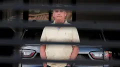 Jair Bolsonaro em uma imagem atrás do portão da casa onde vive em Brasília.