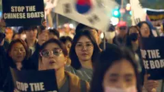 韓國首爾梨泰院一場由「自由大學」組織的反華集會上，一群女示威者舉起「制止中國船隻」標語牌（BBC韓語圖片18/10/2025）